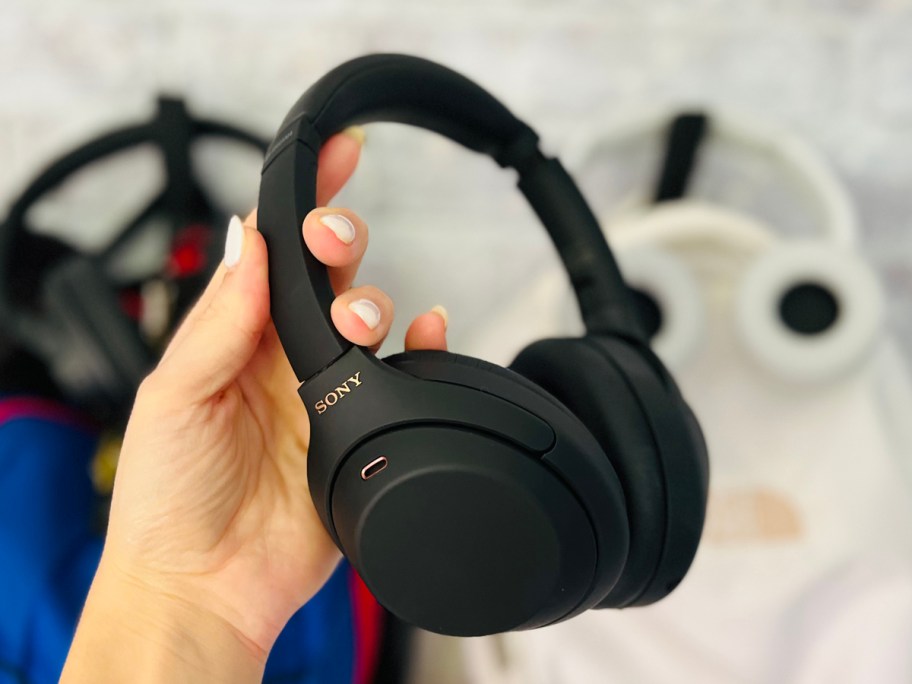 hand holding a pair of black headphones 