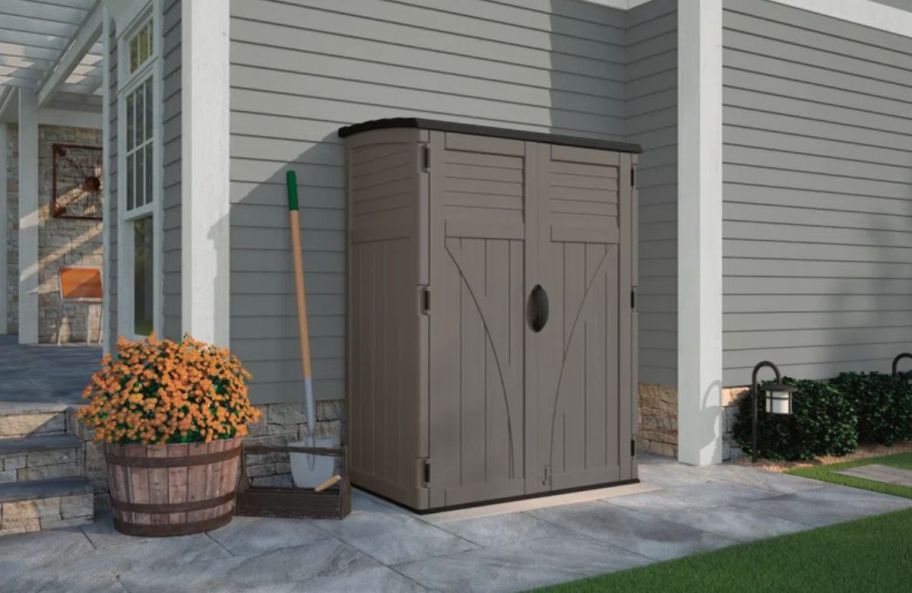 a gray resin shed by the side of a house. 