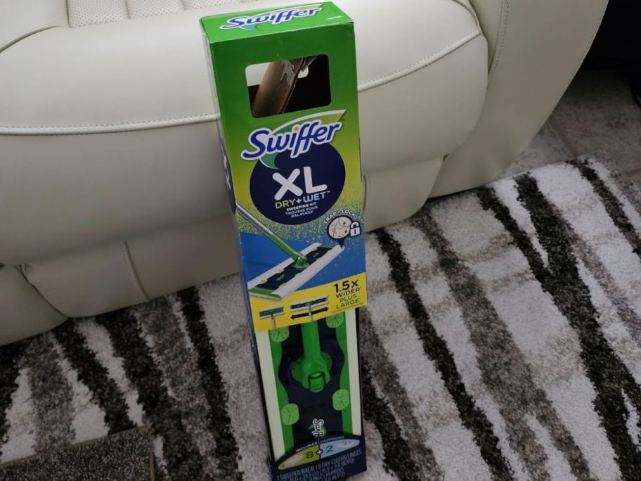 A Swiffer XL Mop on the box set against a chair