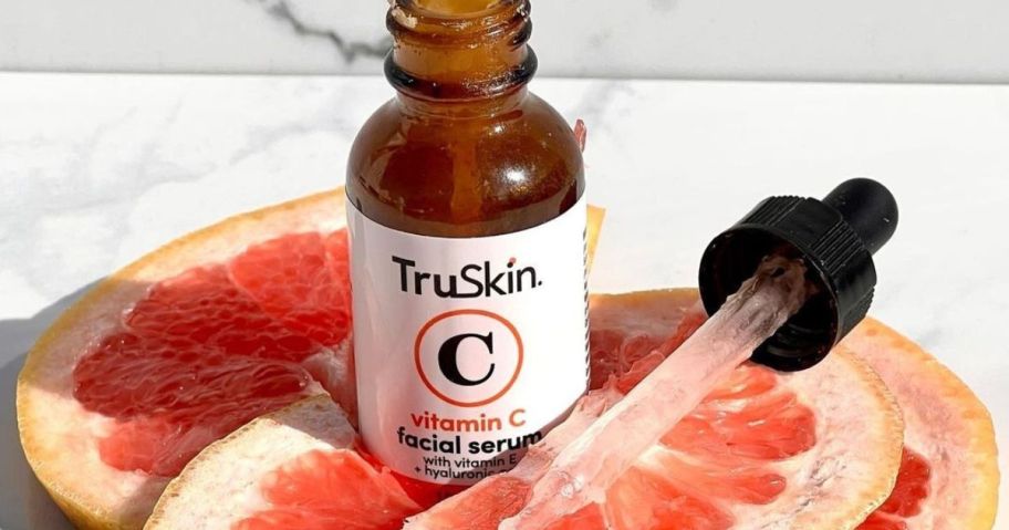 A bottle of TruSkin Vitamin C Serum surrounded by grapefruit slices