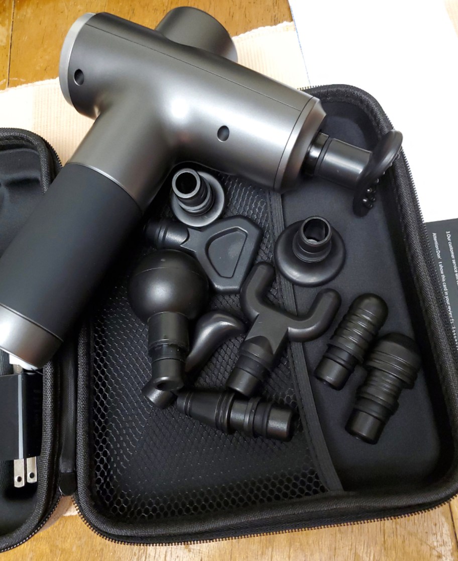 massage gun in travel case with attachments inside