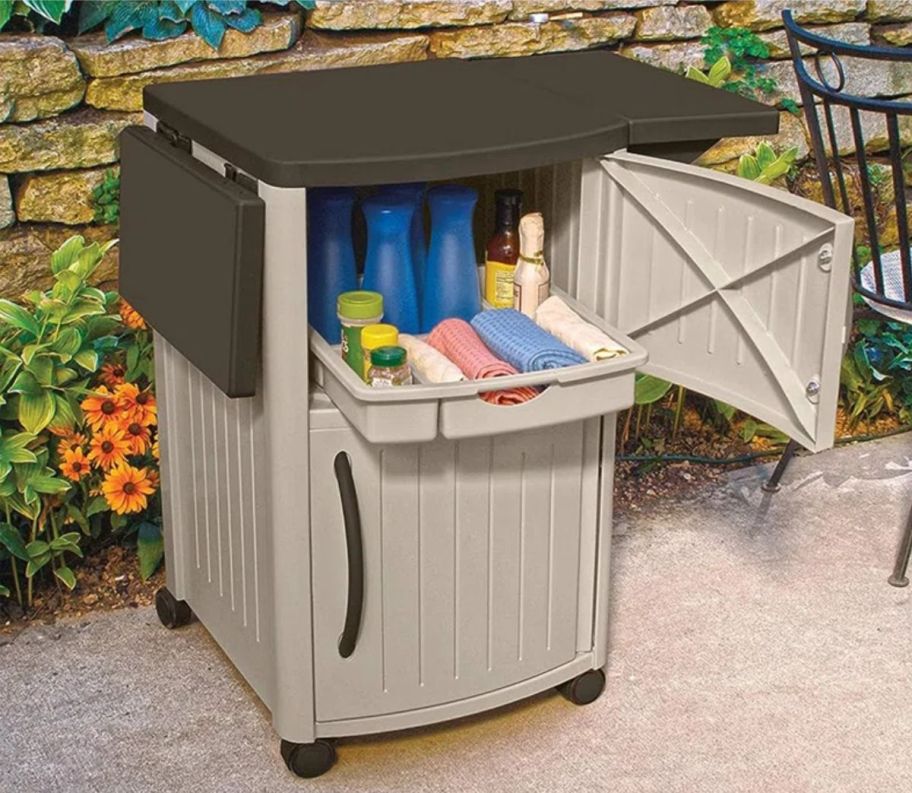 a brown bar cart on a patio with storage door open