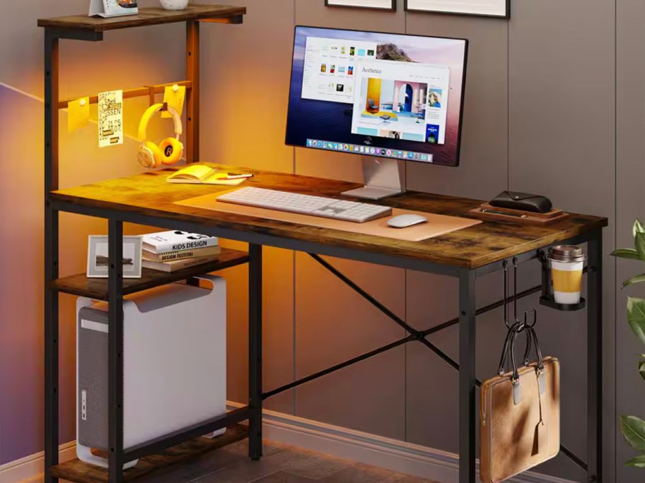 brown and black gaming desk with computer and other items on it