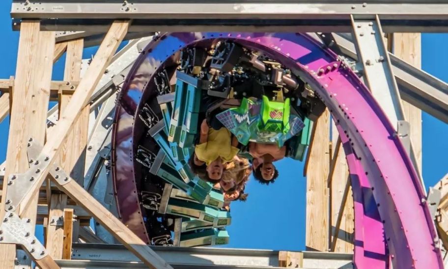 people riding a rollercoaster at a theme park