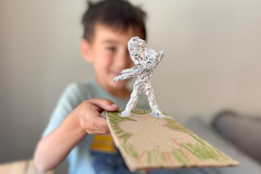 kid holding foil statue