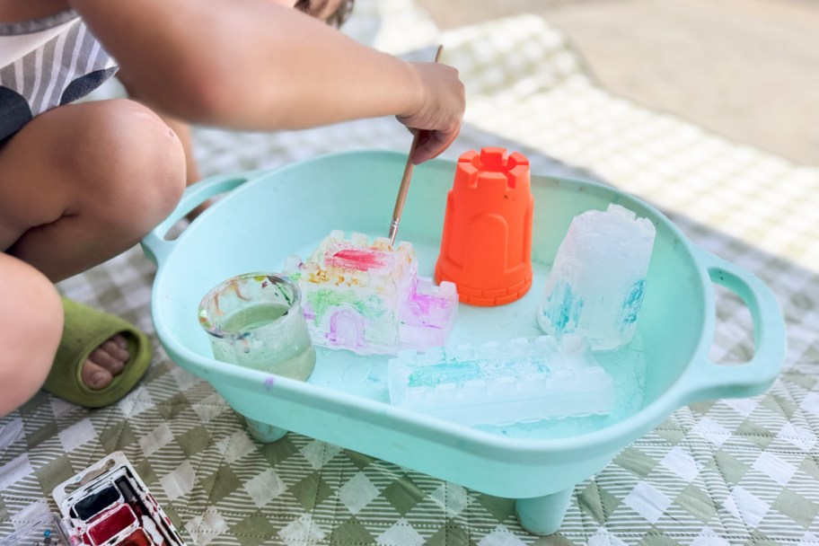 boy painting ice castles in blue container