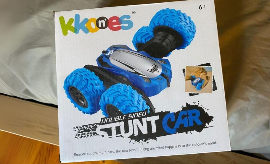 a box containing a blue double-sided remote control car sitting on a hardwood floor