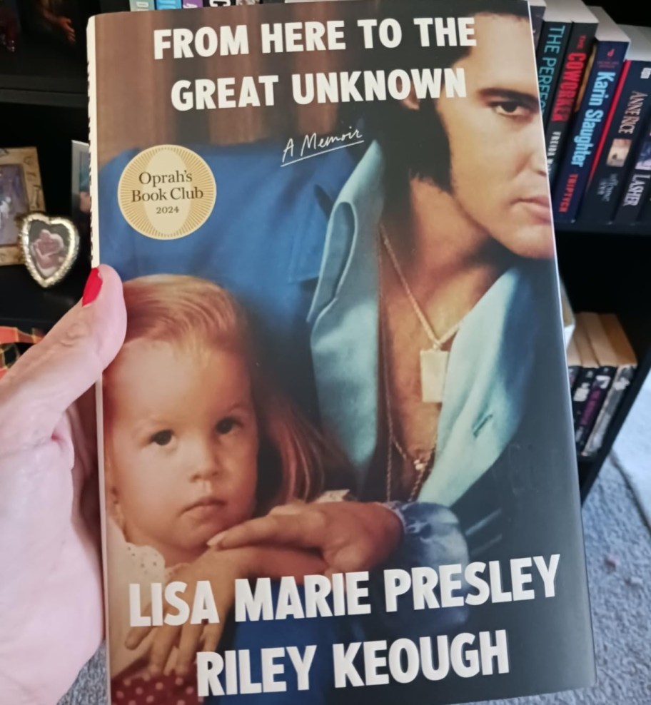 woman holding book with Elvis and Lisa Marie Presley on the cover