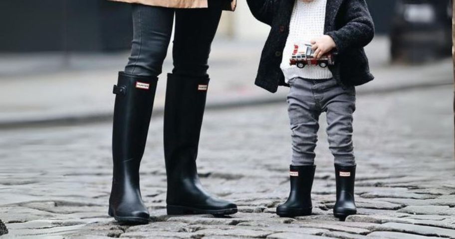 woman and kid wearing hunter boots outside