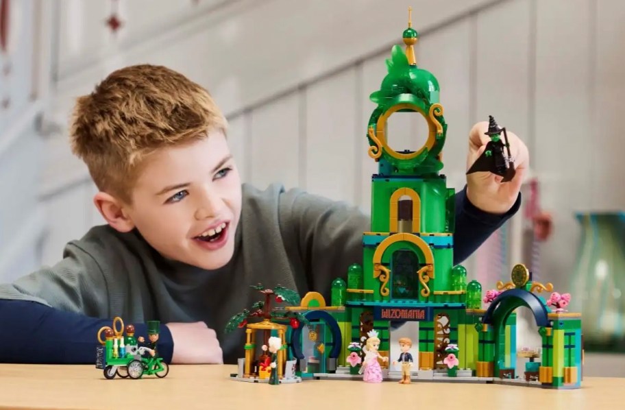 boy playing with lego wicked emerald city set on table