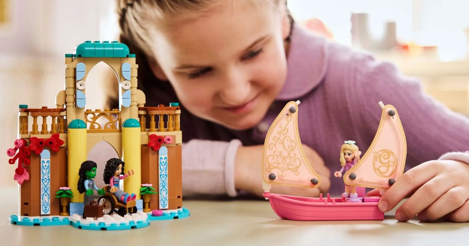 girl playing with LEGO wicked set on table