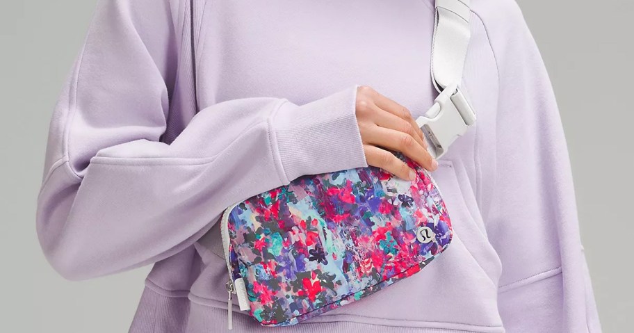 woman in purple sweatshirt and floral print lululemon Everywhere Belt Bag