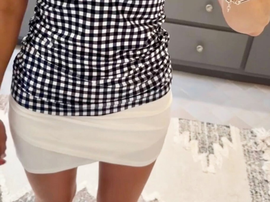 woman in a white swim skirt with black and white gingham top