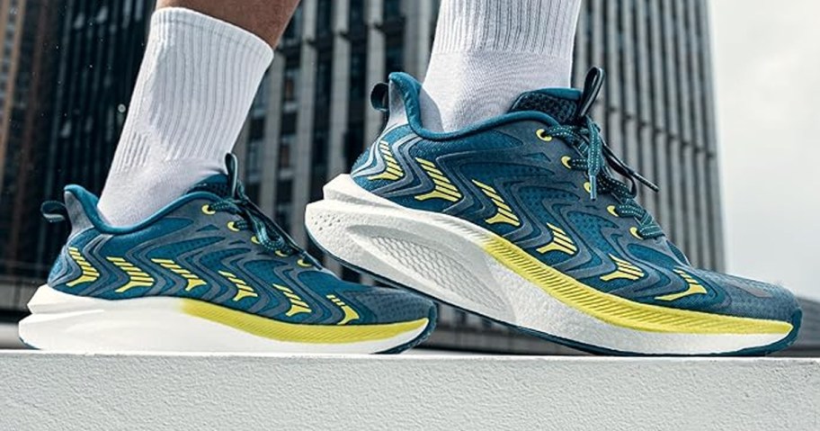 person wearing teal and lime green shoes and white socks 