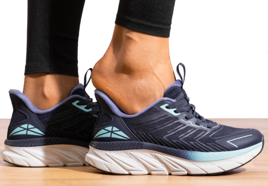 woman putting on navy blue shoes 