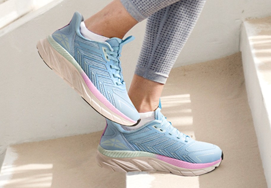 person wearing blue shoes walking up stairs