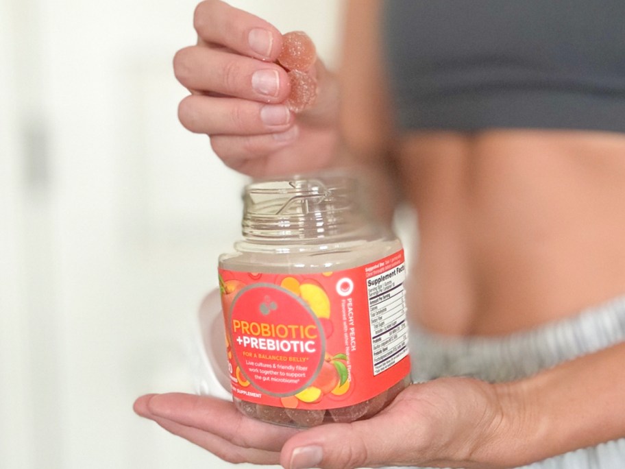 woman taking gummies out of olly probiotic bottle