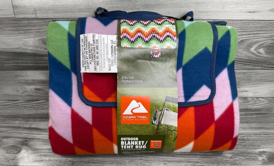 a folded and packaged ozark trail picnic blanket on a hardwood floor