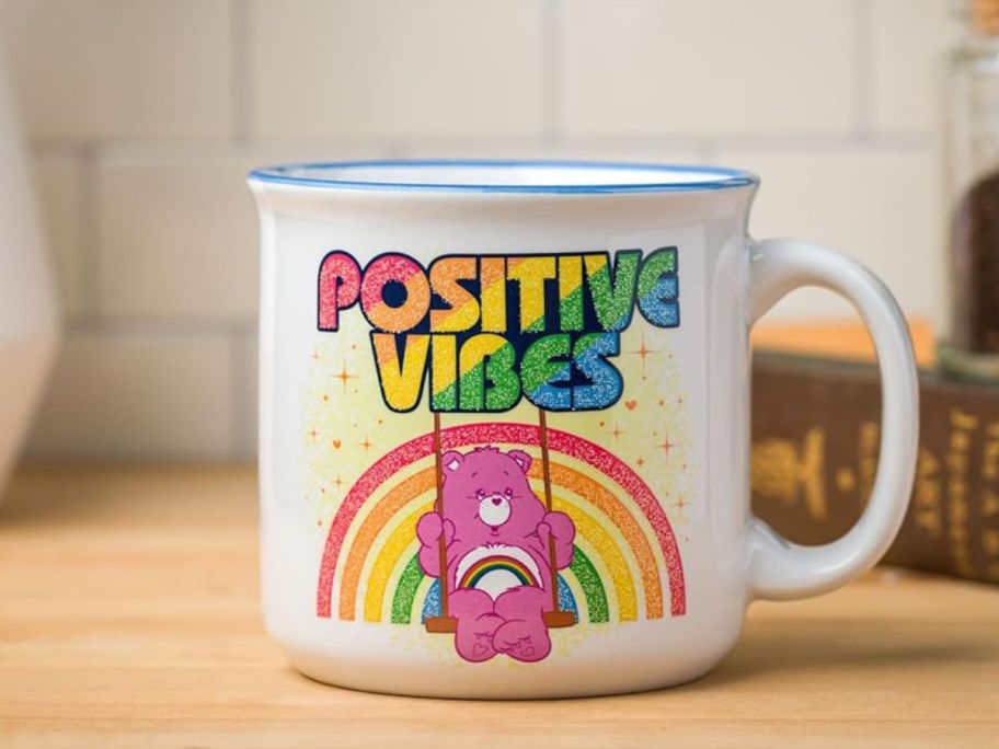 Silver Buffalo Care Bears Cheer Bear Positive Vibes Glitter Ceramic Camper Mug 20oz on counter