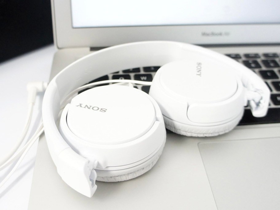 white sony folded headphones laying on laptop