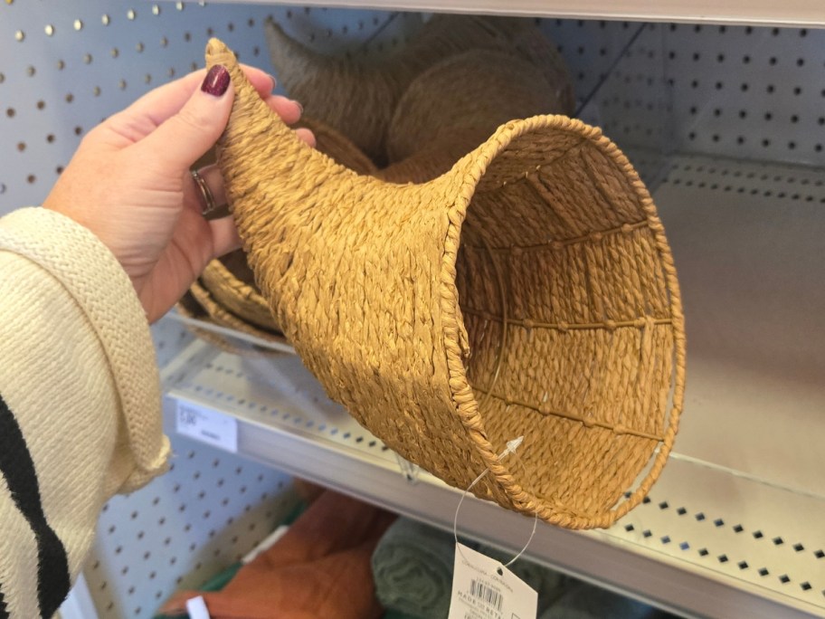 hand holding a horn of plenty / cornucopia woven basket