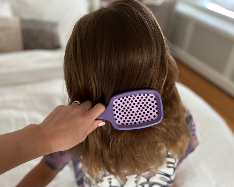 hand brushing little girls hair