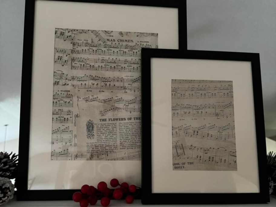 two pieces of sheet music in black photo frames