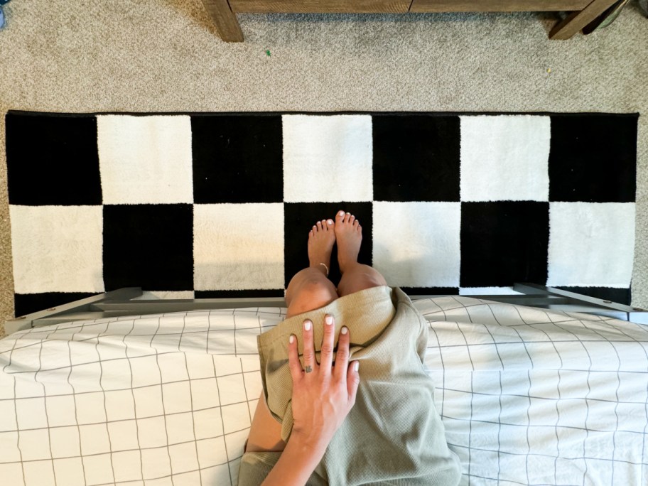 legs sitting over checkerboard rug