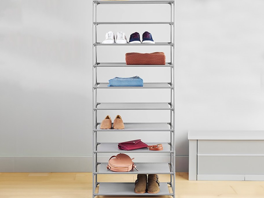 gray storage rack tower with shoes, hat, and bags on shelves