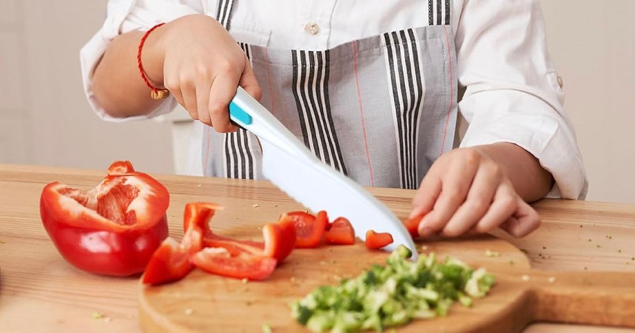 child cutting peppers with knife