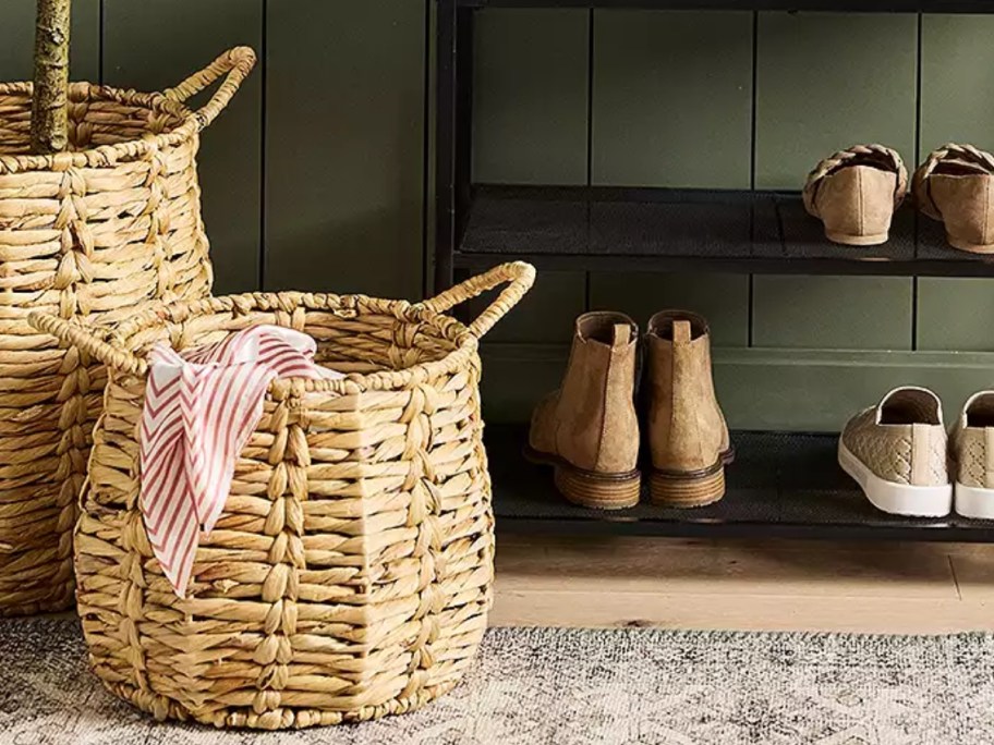 a large round wicker basket with a blanket it in it in an entryway next toa shoe rack