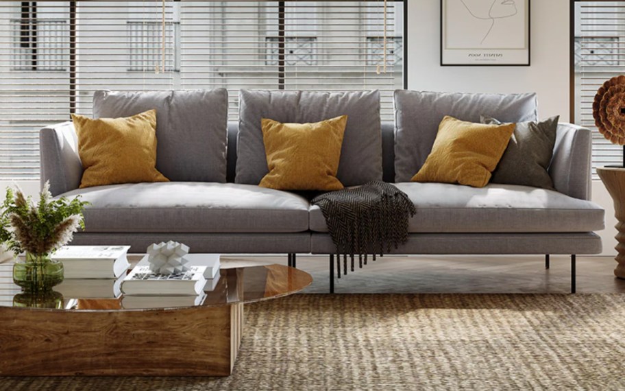 grey high leg sofa with golden pillows