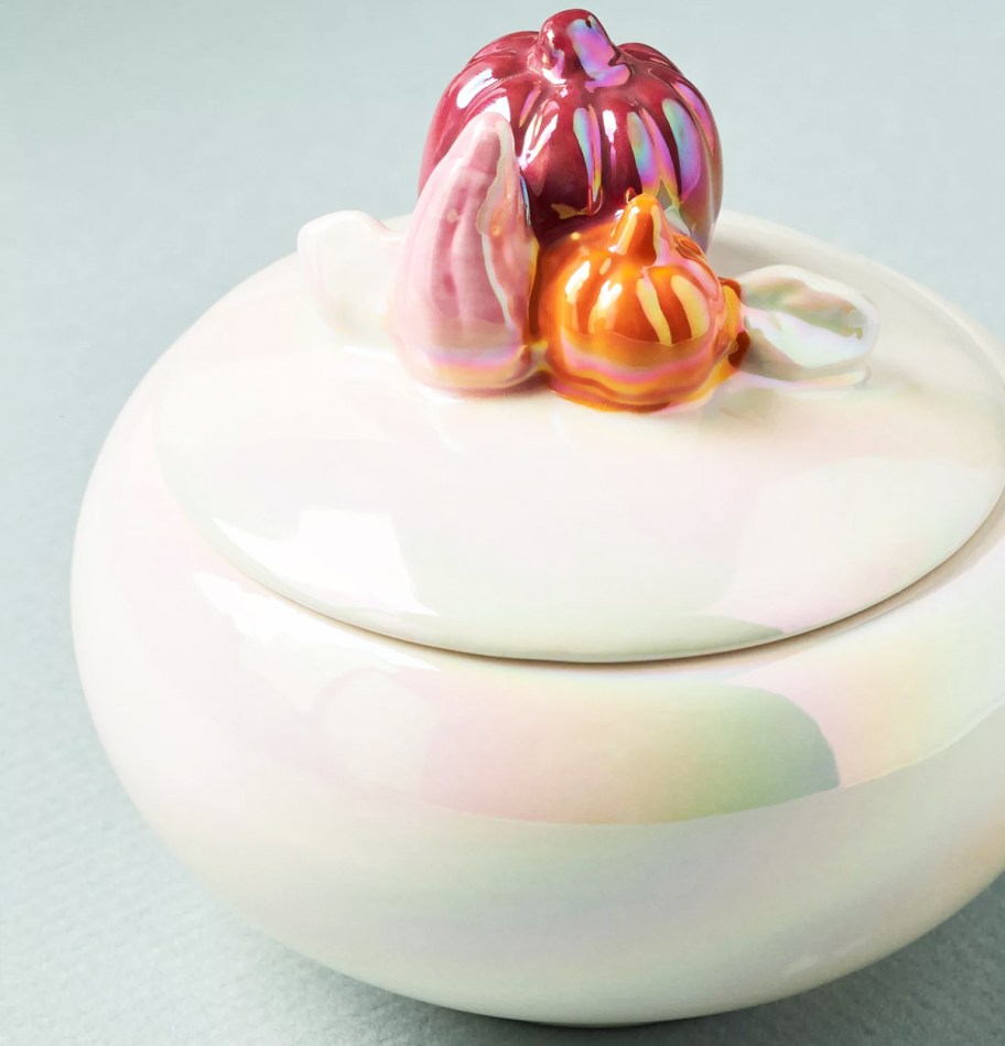 white iridescent jar candle with pumpkins on lid