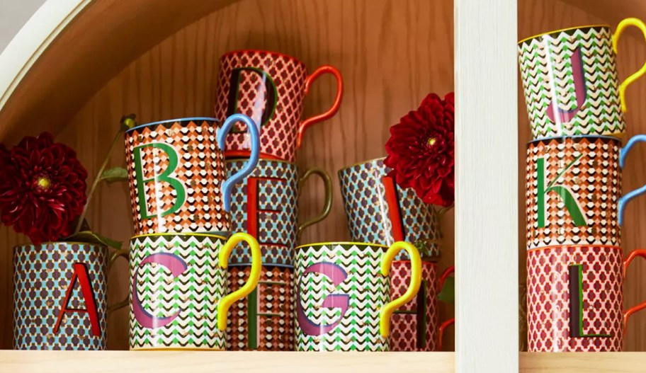 initial letter mugs stacked in cabinet