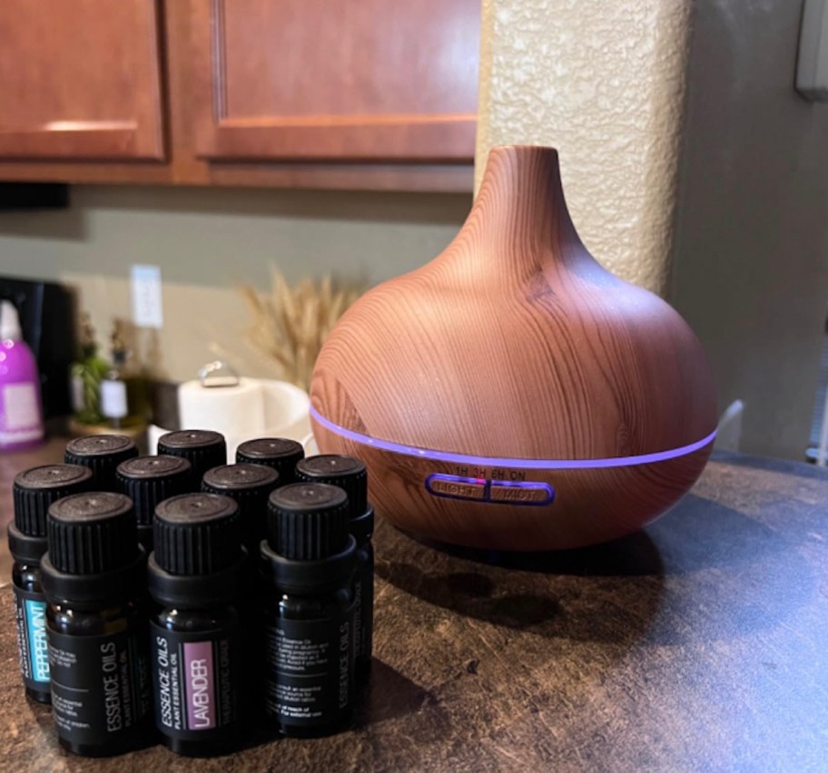 essential oil diffuser on counter with bottles of essential oils