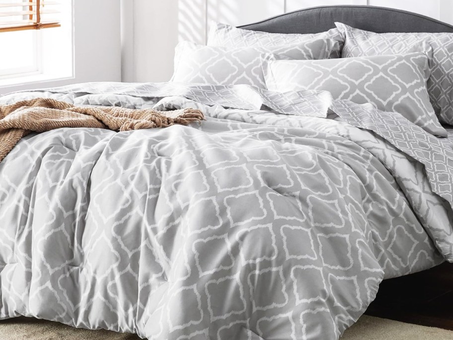 grey and white geometric lattice print comforter with matching shams on a bed