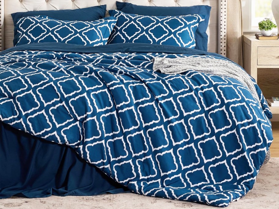 blue and white geometric lattice print comforter with matching shams on a bed