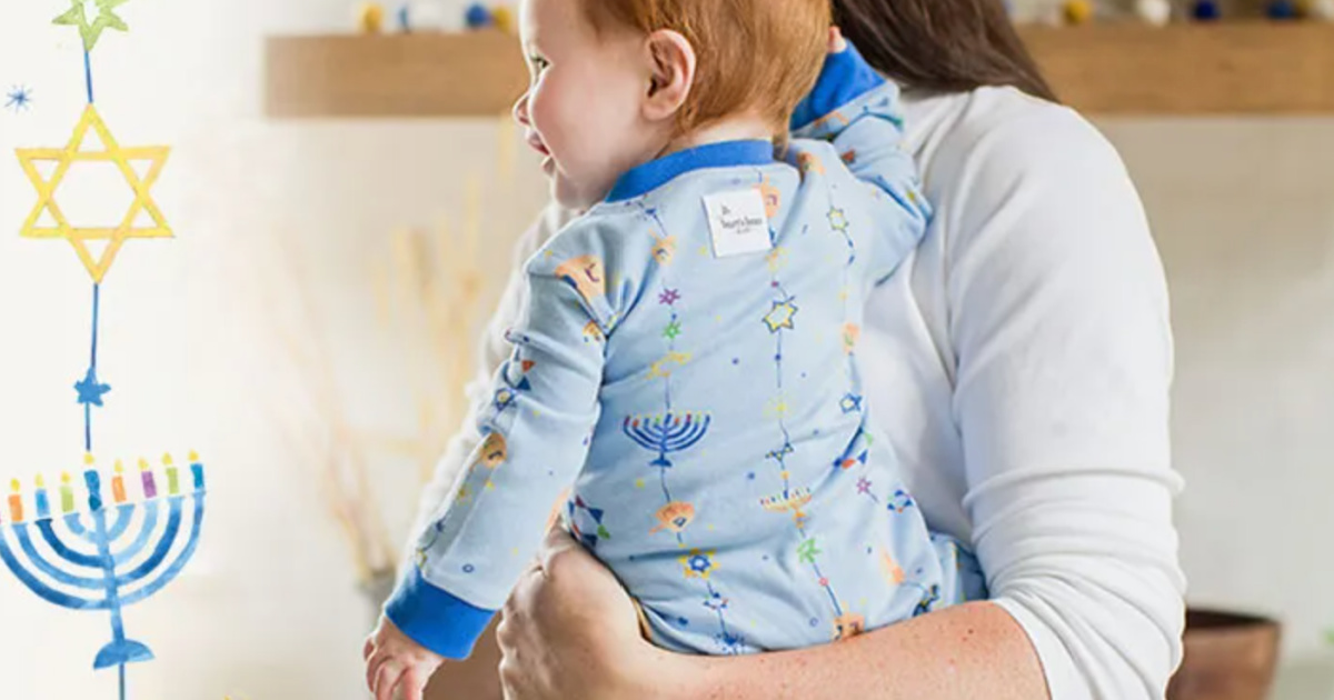 woman carrying baby wearing Burts Bees Hanukkah Pajamas