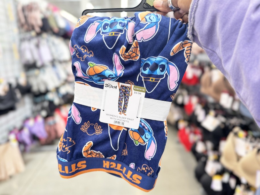 hand holding up a set of stitch halloween print pajama pants