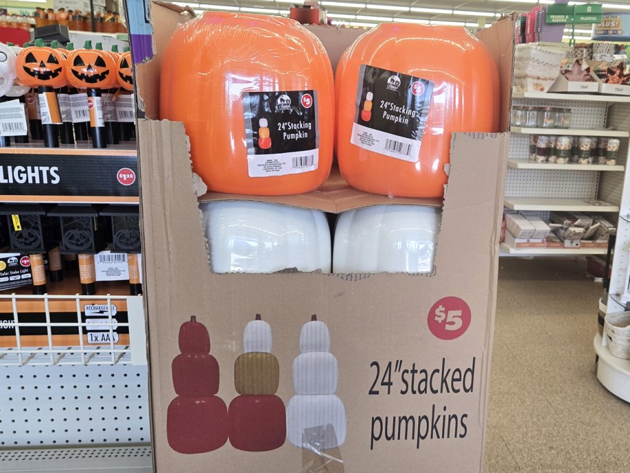 stacking pumpkins sets in cardboard display in store