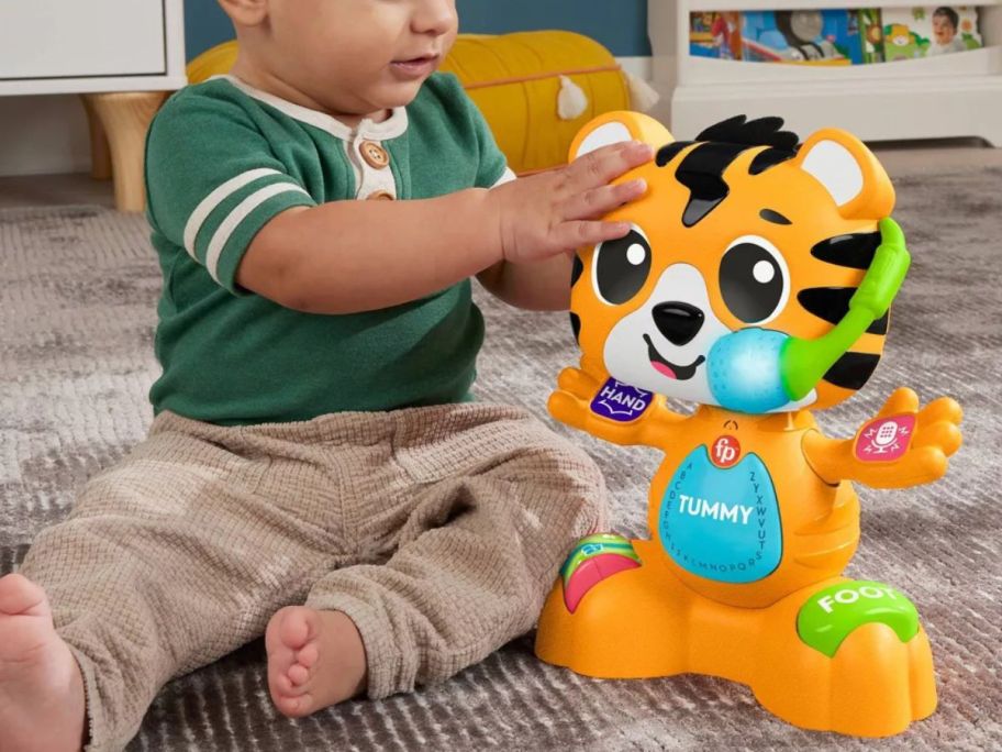 baby playing with Fisher-Price Baby Learning Toy Link Squad Bop & Groove Tiger on floor