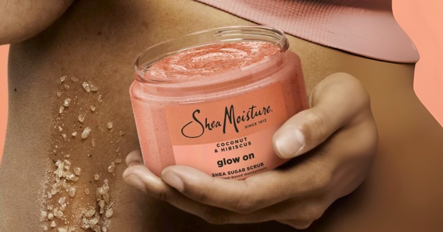 hand holding a container of SheaMoisture body scrub