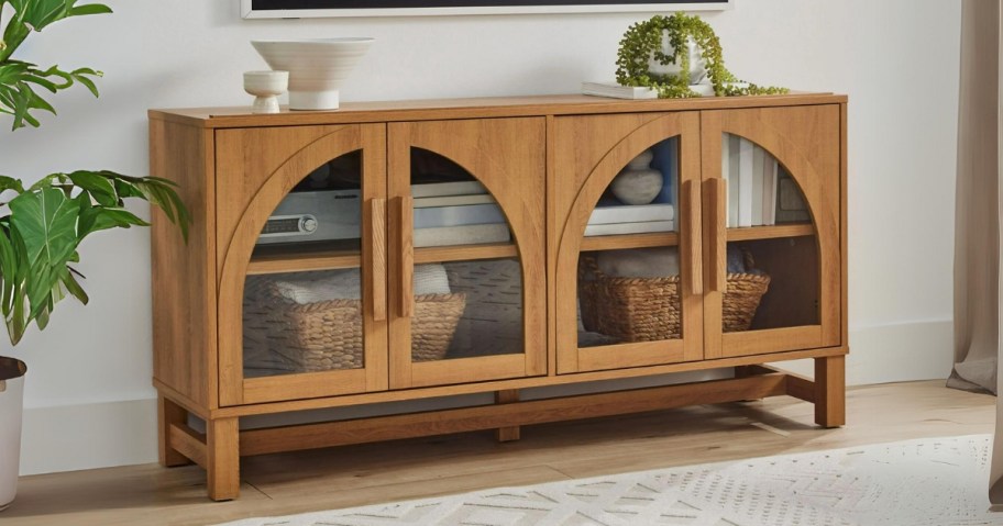 a light honey wood modern style tV stand with arched cut out glass doors