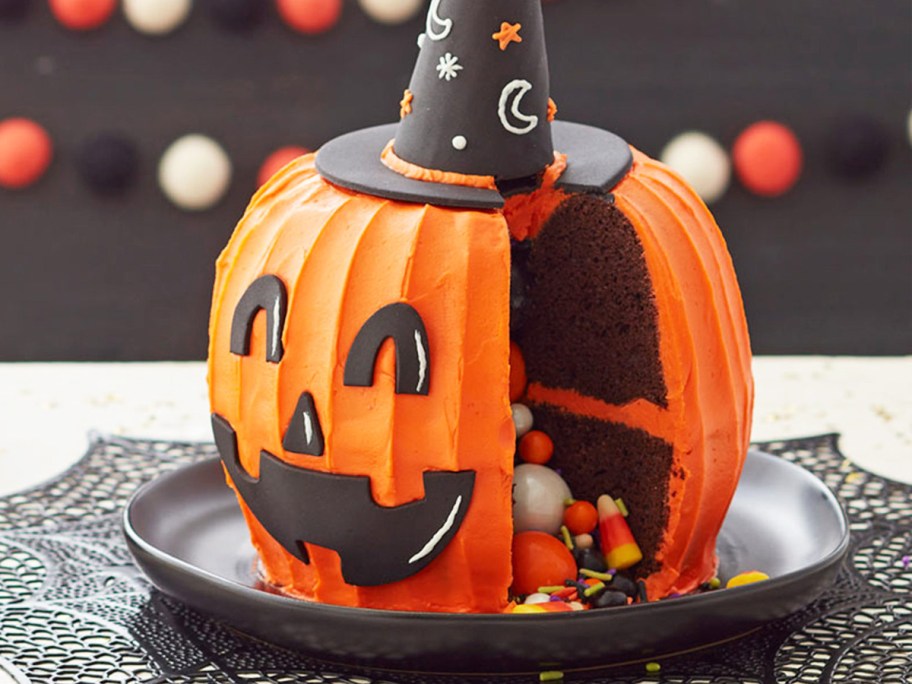 3d pumpkin cake with sprinkles and candies coming out from the center