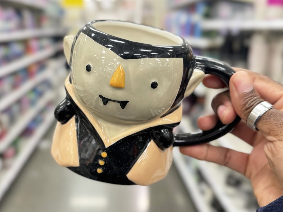 hand holding up a vampire coffee mug