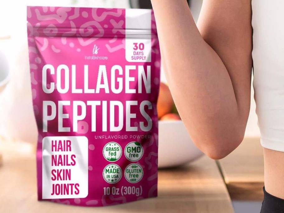 InstaSkincare Collagen Peptide bag on a kitchen counter with a woman standing next to it