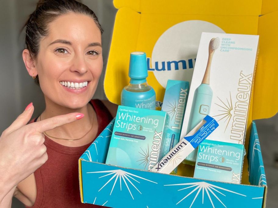 Woman holding a box filled with Lumineux oral care products