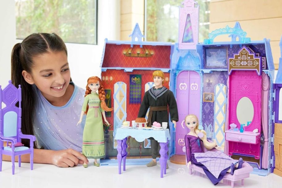 a little girl playing with the frozen ultimate portable castle
