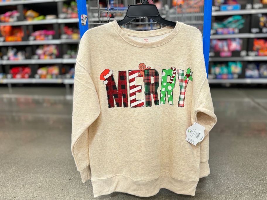 Merry bsweatshirt hanging on the side of a walmart shopping cart