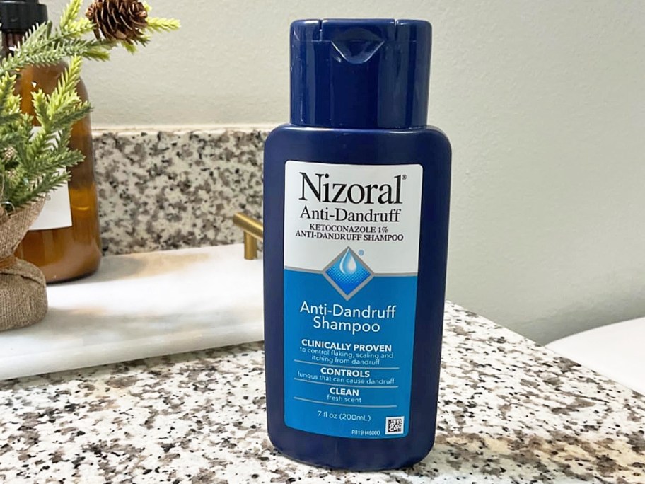 small blue bottle of Nizoral Anti-Dandruff Shampoo on bathroom counter